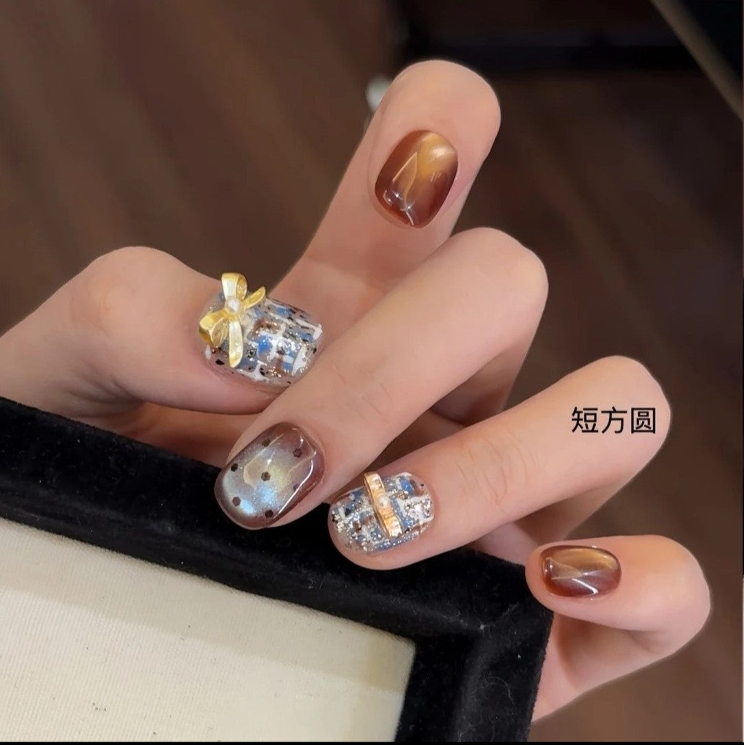 Handmade brown and blue Chanel-style high-end plaid short nails with bow, glass beads, and cat-eye effect for the new autumn and winter season